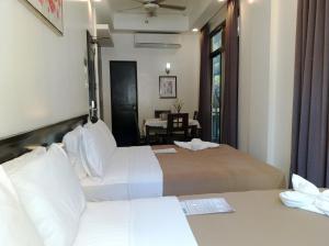 ボラカイにあるワン クレセント プレイス ホテルのベッド2台とテーブルが備わるホテルルームです。