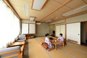 two women sitting at a table in a room at Grampus Sea in Shirahama