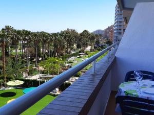 einen Balkon mit einem Tisch und Blick auf ein Resort in der Unterkunft Frontal en primera linea Vistamar 3 in Oropesa del Mar