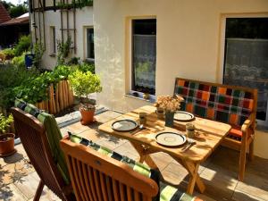 a wooden table and chairs on a patio at Berghof in Zeulenroda