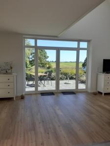 an empty living room with a large sliding glass door at Pilsumer Warfthaus in Krummhörn
