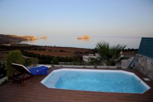 a swimming pool on a patio with a view of the ocean at Krinakia Villas in Xerokampos