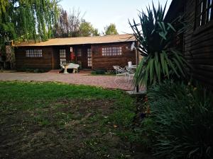 a log cabin with a picnic table in front of it at The Log Cabin Apartments Hotel in Standerton