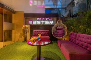 a room with purple couches and a table and a sign at Hotel Oriental Aster- Mumbai International Airport in Mumbai