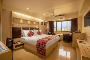 
a hotel room with a large bed and a large window at Hotel Oriental Aster- Mumbai International Airport in Mumbai
