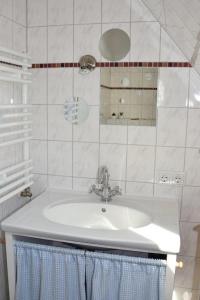 W białej łazience znajduje się umywalka i lustro. w obiekcie Ferienwohnung Lahann w mieście Bokelrehm