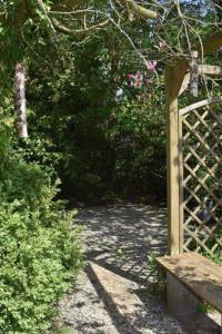 un banc en bois dans un jardin avec une clôture dans l'établissement Ferienwohnung Lahann, à Bokelrehm