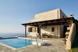a villa with a swimming pool and a building at The Pool Garden House with a fantastic sea and sunset view in Ioulis