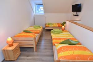 a room with three beds and a tv in it at Chata PELC in Stratená