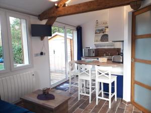 - une cuisine avec une table et des chaises dans la chambre dans l'établissement CHALET DU LAC PISCINE à 5 MINUTES DE DISNEY TGV RER, à Montévrain