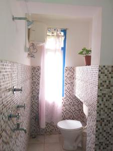 bagno con servizi igienici e finestra. di Ashraya Boutique Homestay a Rongli