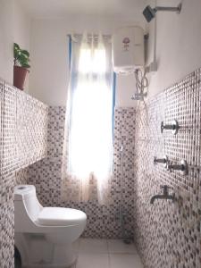 a bathroom with a toilet and a shower with a window at Ashraya Boutique Homestay in Rongli