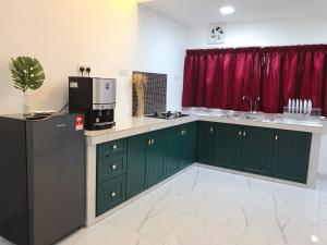 a kitchen with green cabinets and a black refrigerator at Botanic Gardens 26- 5-bedroom Near AEON Bukit Tinggi in Klang