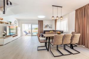a dining room and living room with a table and chairs at Villa Insula Aurea No.1 in Linardići
