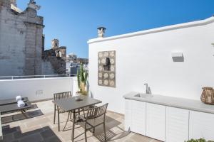 a patio with a table and chairs on a balcony at Palazzo Mulini in Monopoli