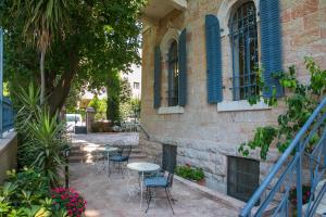 a patio with chairs and a table in front of a building at Villa Brown Moshava - a member of Brown Hotels in Jerusalem