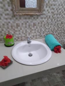 a white bathroom sink with a green and red towel at Cenik House Ubud in Ubud