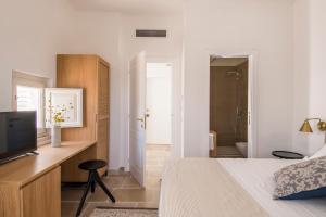 a bedroom with a bed and a desk with a television at Palazzo Mulini in Monopoli