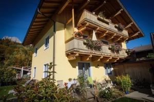 a man sitting outside of a house with a balcony at Appartements Spielberg in Leogang