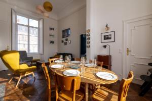 una sala da pranzo con tavolo in legno e sedie gialle di Le Scenario a Carentan
