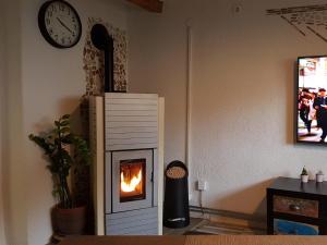 a room with a fireplace and a clock on the wall at Chalet am Park in Piesendorf