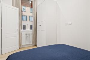 - une chambre avec un lit bleu et une fenêtre dans l'établissement Piazza Maggiore White Apartment, à Bologne