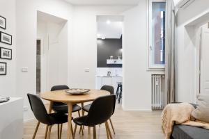 Il comprend une cuisine et une salle à manger avec une table et des chaises en bois. dans l'établissement Piazza Maggiore White Apartment, à Bologne