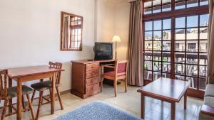 a living room with a television and a desk with a table at Be Smart Florida Plaza in Puerto de la Cruz