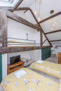 a bedroom with two beds and a tv in a room at Airton Mill in Airton
