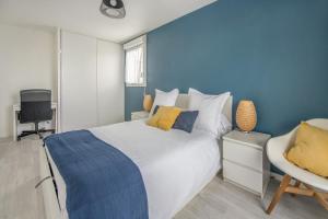 ein Schlafzimmer mit einem weißen Bett und einer blauen Wand in der Unterkunft Bel appartement de 2 chambres à 40 min de Paris in Courcouronnes