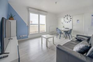 - un salon avec un canapé et une table dans l'établissement Bel appartement de 2 chambres à 40 min de Paris, à Courcouronnes