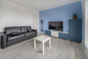 ein Wohnzimmer mit einem Sofa und einem Tisch in der Unterkunft Bel appartement de 2 chambres à 40 min de Paris in Courcouronnes