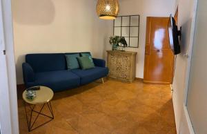 sala de estar con sofá azul y TV en My Sicilian Escape, en Cefalú