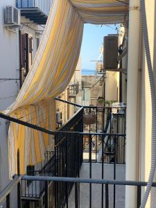 vistas a un balcón con cortinas en un edificio en My Sicilian Escape, en Cefalú
