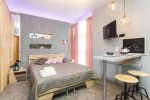 a bedroom with a bed and a table and a desk at EtazhiDaily in Centre in Yekaterinburg