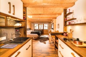 a kitchen with wooden ceilings and a bedroom with a bed at Chalet Harmonie in Inzell