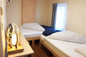 2 camas en una habitación con ventana en SappoLodge, en Sapporo