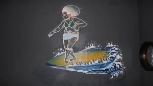 een schilderij van een vrouw op een golf op een surfplank bij Soul House in Durban