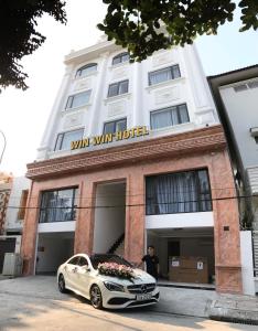 a white car parked in front of a hotel at Win Win Hotel - Khách Sạn Hải Phòng in Hai Phong