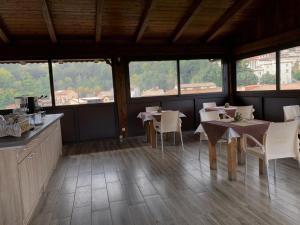 a dining room with tables and chairs and windows at B&B L’antico Rudere in Cosenza