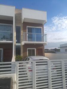 una casa con una cerca blanca delante de ella en Sobrado novo, en Florianópolis