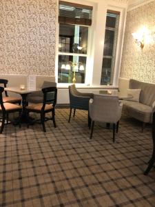The Clarendon Hotel في موركامب: غرفة معيشة مع أريكة وطاولة وكراسي