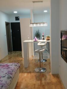 eine Küche und ein Wohnzimmer mit einem Tisch und einem Bett in der Unterkunft Apartman Lux in Nova Pazova