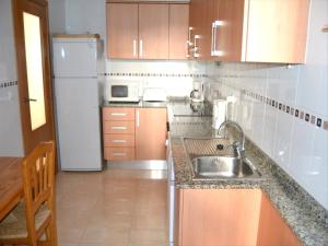 een kleine keuken met een wastafel en een koelkast bij Apartamento Benvinguts I in Jávea