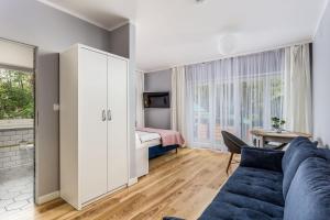 a living room with a couch and a bedroom at Żabba in Pobierowo