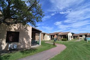a house with a driveway and a grass yard at Li Suari Club Village in San Teodoro