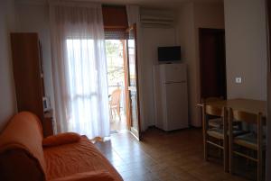 a living room with a couch and a table and a refrigerator at Condominio San Michele in Bibione