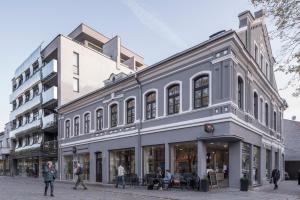 a building with people walking in front of it at Laisves ave. Apartments in Kaunas