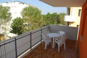 d'un balcon avec une table et des chaises. dans l'établissement Condominio San Michele, à Bibione
