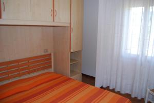 - une chambre avec un lit et un rideau blanc dans l'établissement Condominio San Michele, à Bibione